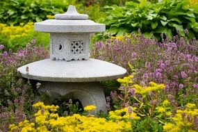 stone sculpture among flowers in the garden