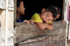 young boys behind a wooden fence