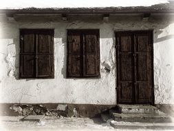 old building with wooden windows and a door