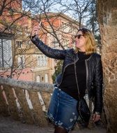 girl takes a selfie at a tree in the city