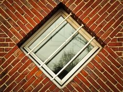 diamond-shaped window on a brick facade