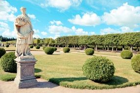 woman with fruits, sculpture in park on sunny day