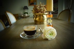 white rose near a cup of coffee