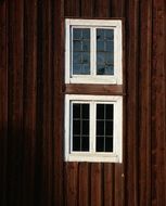 two white Windows in brown Wooden Facade