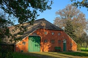 Old red brick building with barn at countryside, germany, East Frisia