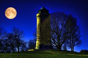tower against the background of the full moon in the sky
