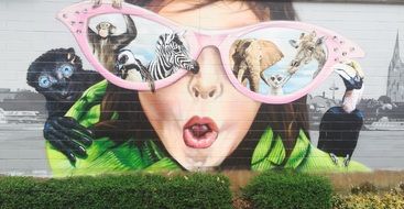 graffiti in the form of a female face with glasses on the wall