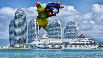 Photographer, Giant toy Frog with camera behind city skyline