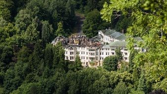 big destroyed hotel building in the forest