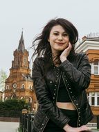 brunette in a leather jacket on the background of the historic cathedral