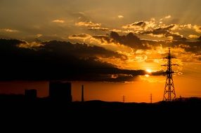 electric poles on a hill during sunset