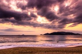 dark purple clouds over the sea at sunset
