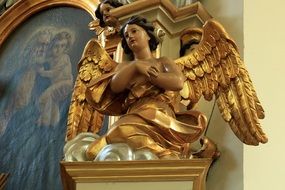 golden angel as a sculpture on the altar in the church