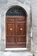 Wooden door to the house made of natural stone