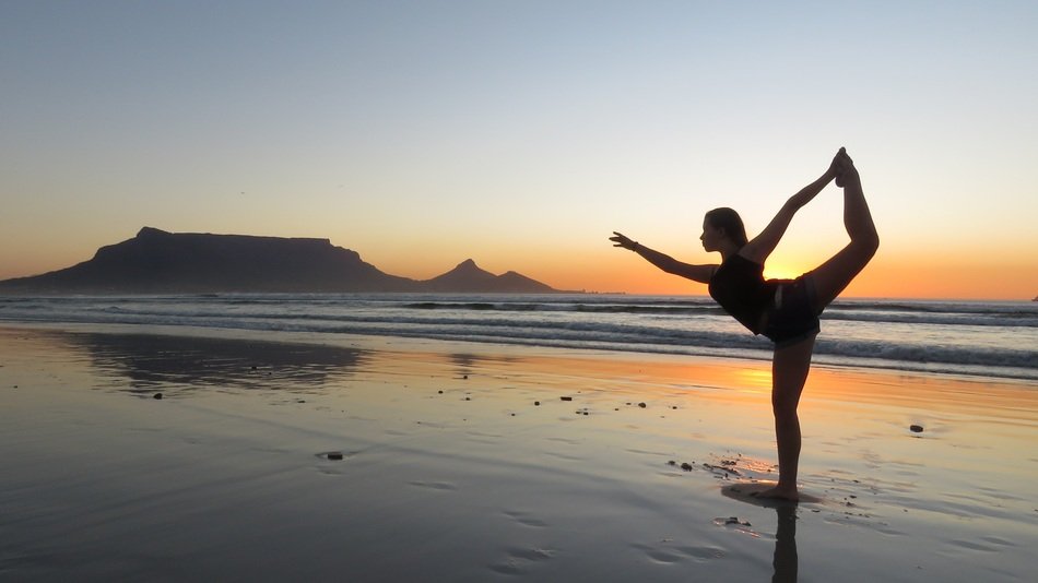 girl doing yoga on the beach