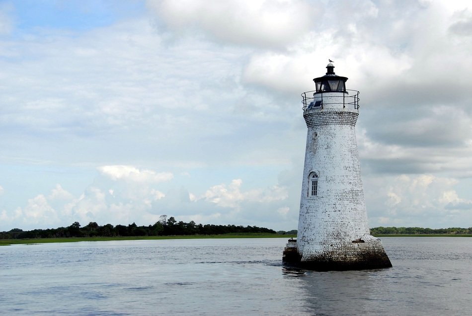 white historic lighthouse in the water