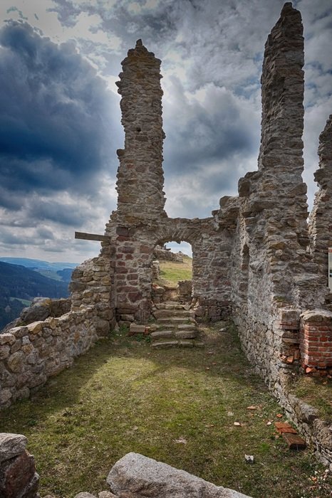 aged brick ruin on mountain at cloudy sky