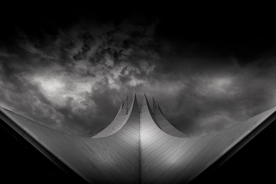 monochrome photo of futuristic roof construction at dramatic clouds, germany, berlin