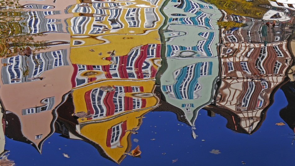distorted reflection of houses on the water