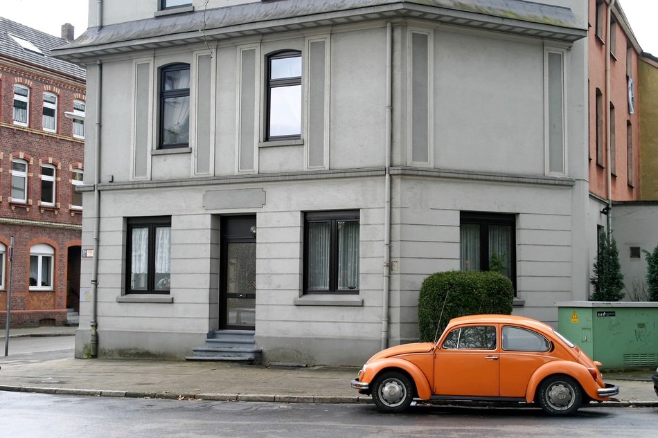 orange car stands near the house
