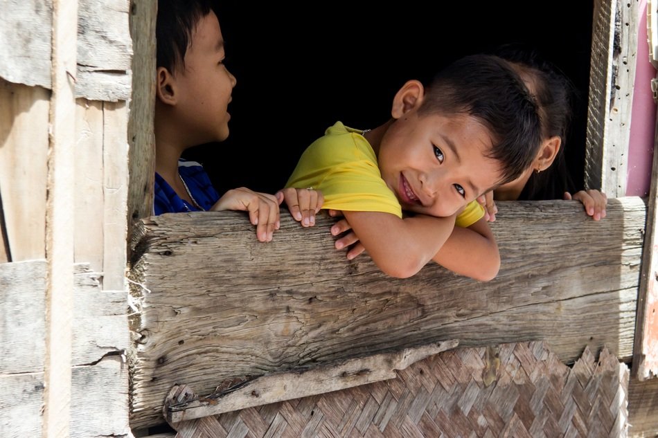 young boys behind a wooden fence