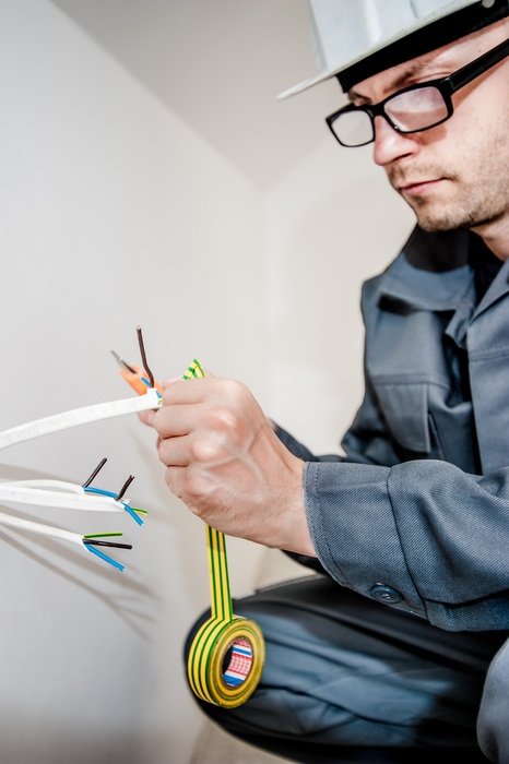portrait of electrician doing ground wire insulation
