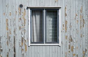 Window in wooden facade with Exfoliated Paint