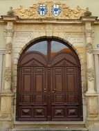 two coats of arms above input door of historical building