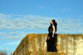 girl in black dress posing on the wall