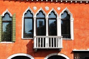 unusual windows on the orange facade of a historic building