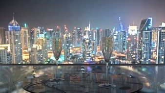 two glasses of champagne on a table against the background of the panorama of Dubai