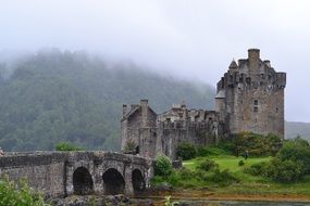 medieval Castle at foggy mountain, uk, Scotland