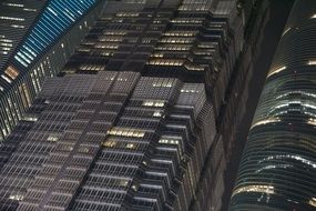 view from below of skyscraper with light in the windows at night