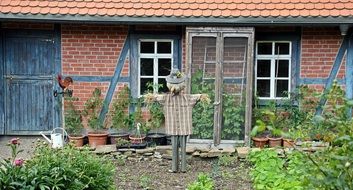 scarecrow in front of a rural house