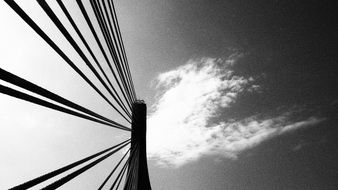 suspension bridge against the sky in black and white