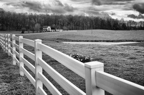 black and white photo of a wooden fence on the field