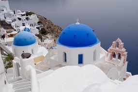 panoramic view of white buildings with blue domes in Santorini