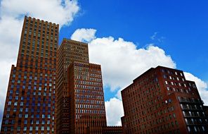 red High-Rise buildings at blue sky with white fluffy clouds