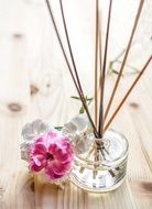 pink flower near aroma sticks on the table