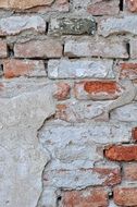 crumbled plaster of on the brick wall