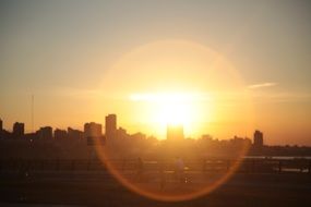 orange setting sun over city skylines