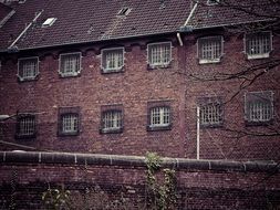 old brick Prison building with grated windows