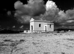 Black and white photo of the clouds over the chapel on the field