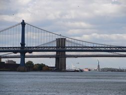 brooklyn bridge on the background of the statue of liberty