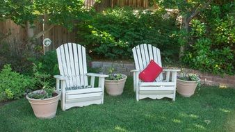 two white wooden chairs in the backyard