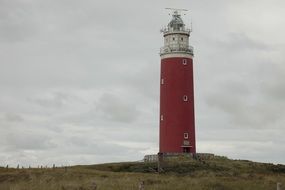 lighthouse with red walls on a hill