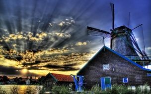 farmhouse and windmill on a beautiful sunset background