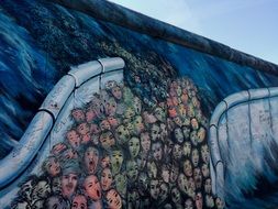 graffiti in the form of people's heads on a wall in Berlin