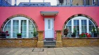 scenic House with white arched windows on pink facade