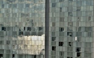 facade of a glass office building with the light reflection in New York